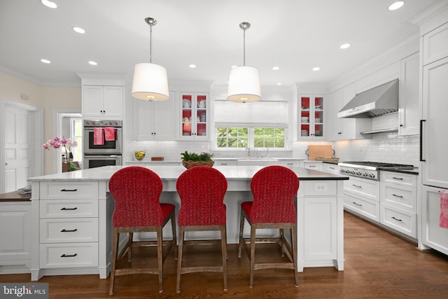 809 Cornell St, Fredericksburg, VA 22401 - kitchen featuring crown molding, appliances with stainless steel finishes, wall chimney exhaust hood, a center island, and glass insert cabinets