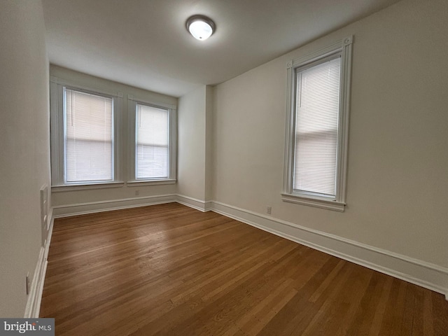 empty room featuring baseboards and wood finished floors