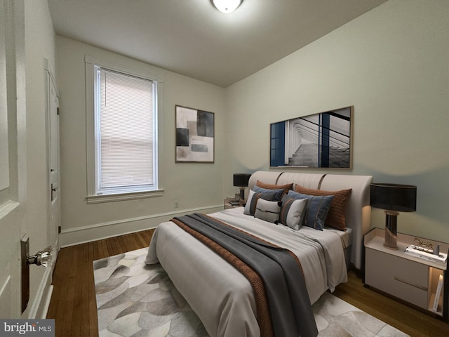 bedroom featuring baseboards and wood finished floors