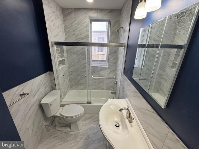 full bath featuring toilet, marble finish floor, enclosed tub / shower combo, and a sink