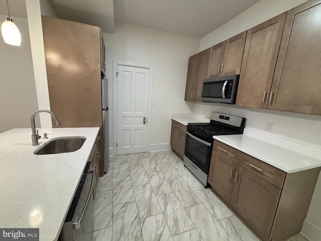 kitchen with light stone counters, a sink, baseboards, marble finish floor, and appliances with stainless steel finishes