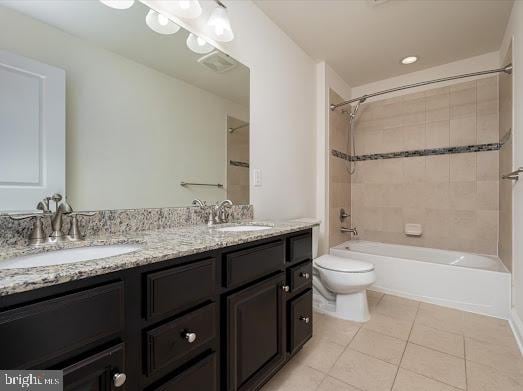 bathroom featuring double vanity, a sink, toilet, and tile patterned floors