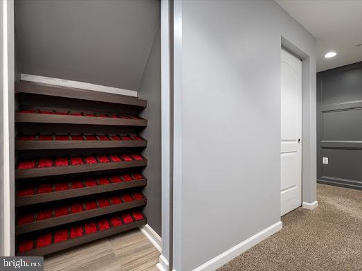 wine room with baseboards, light colored carpet, and recessed lighting