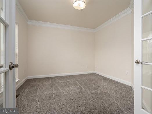 carpeted spare room featuring baseboards, crown molding, and french doors