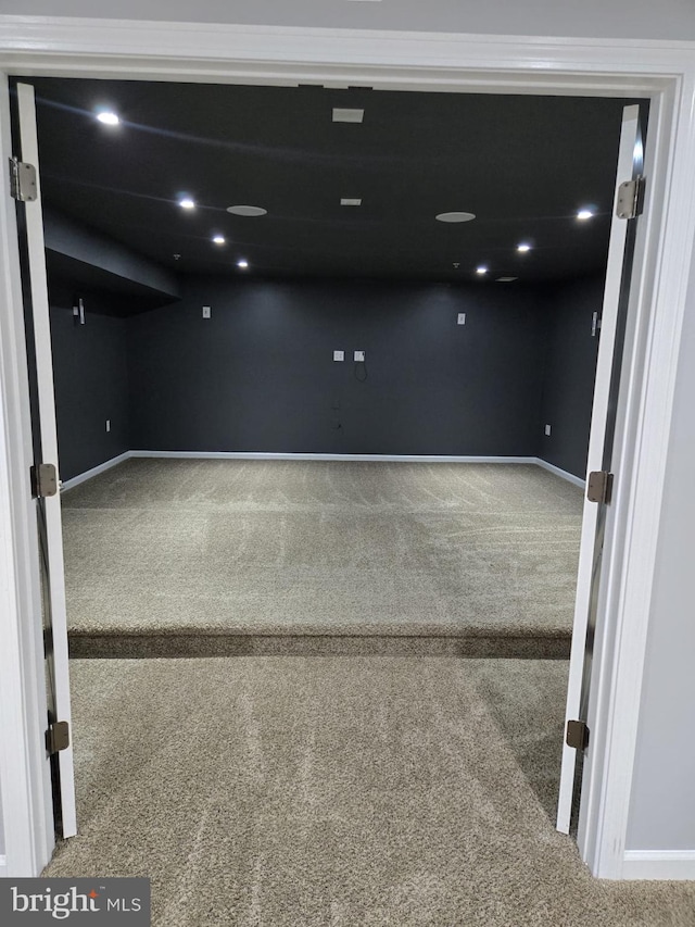 carpeted spare room featuring baseboards