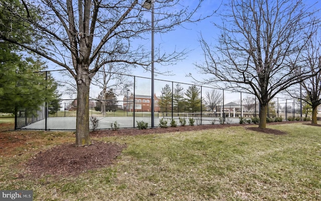 view of yard with a tennis court and fence