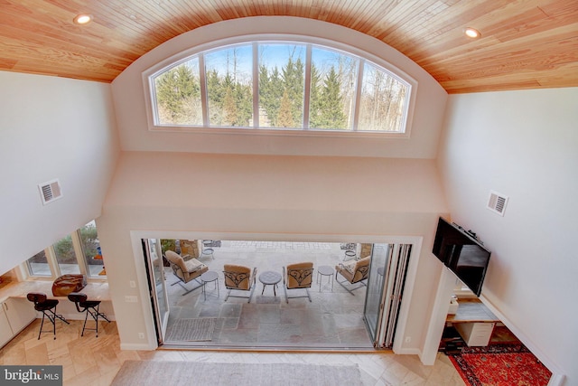 foyer featuring lofted ceiling, wooden ceiling, and visible vents