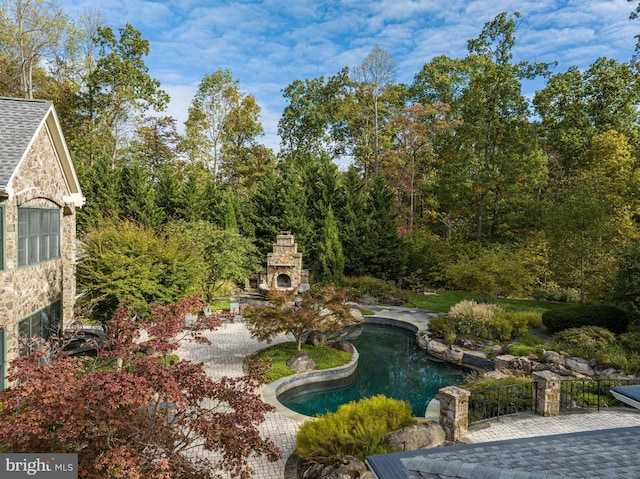 view of yard featuring a patio area and an outdoor stone fireplace