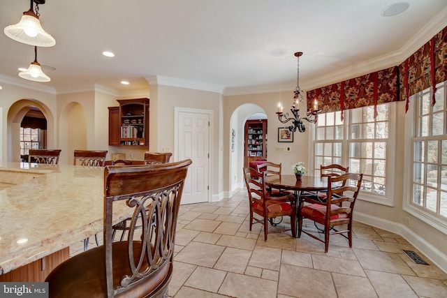 dining space with arched walkways, crown molding, a notable chandelier, visible vents, and baseboards