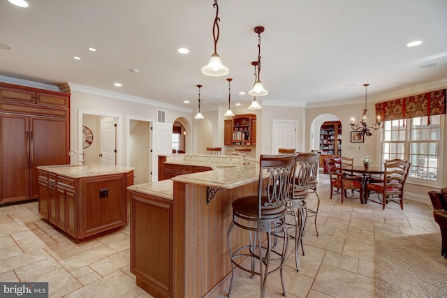 kitchen with arched walkways, a spacious island, paneled built in fridge, a kitchen breakfast bar, and brown cabinetry