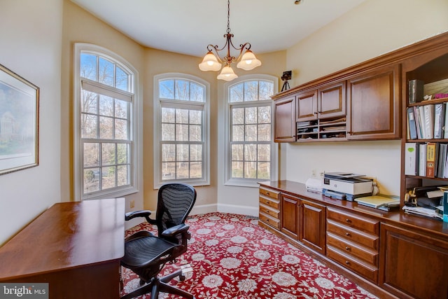 home office with an inviting chandelier and baseboards