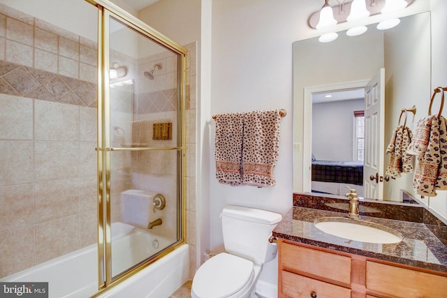 bathroom with combined bath / shower with glass door, vanity, and toilet