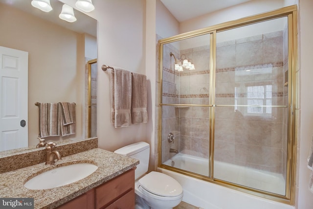 bathroom with toilet, vanity, and enclosed tub / shower combo