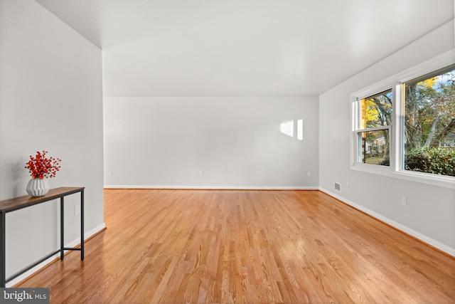 unfurnished room with visible vents, light wood-style flooring, and baseboards