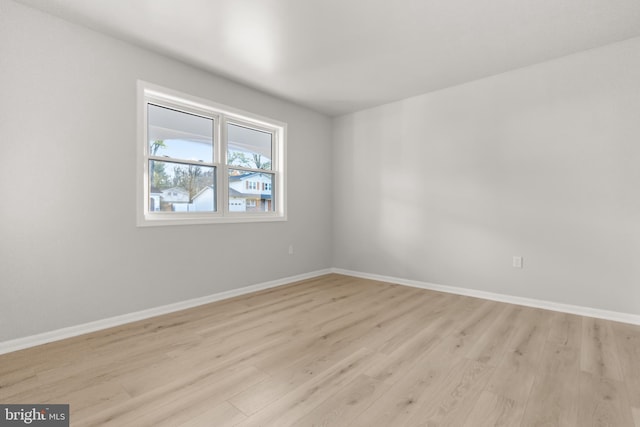 spare room with light wood-style floors and baseboards