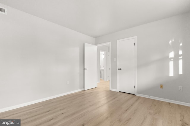 interior space featuring light wood-style floors, visible vents, and baseboards