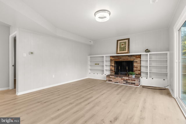 unfurnished living room with visible vents, a fireplace, baseboards, and wood finished floors