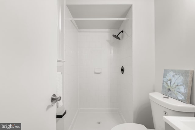 bathroom with tiled shower and toilet