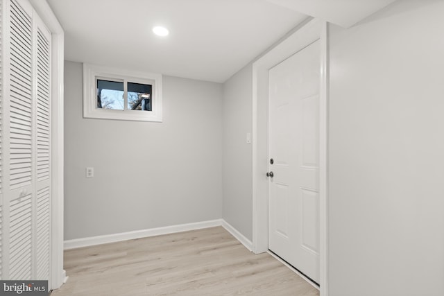 basement featuring light wood-style flooring and baseboards