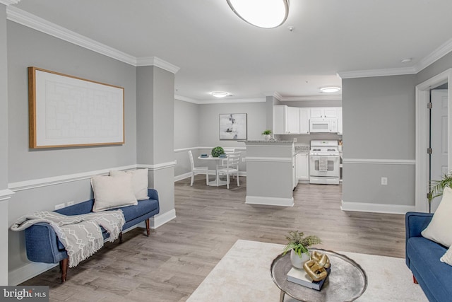 living area with light wood-type flooring, crown molding, and baseboards