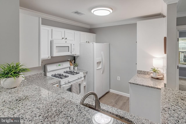 kitchen with white appliances, white cabinetry, light stone countertops, and crown molding