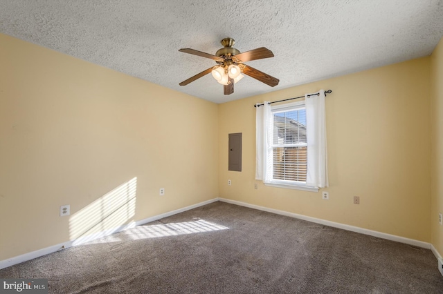 spare room with a textured ceiling, ceiling fan, baseboards, electric panel, and carpet