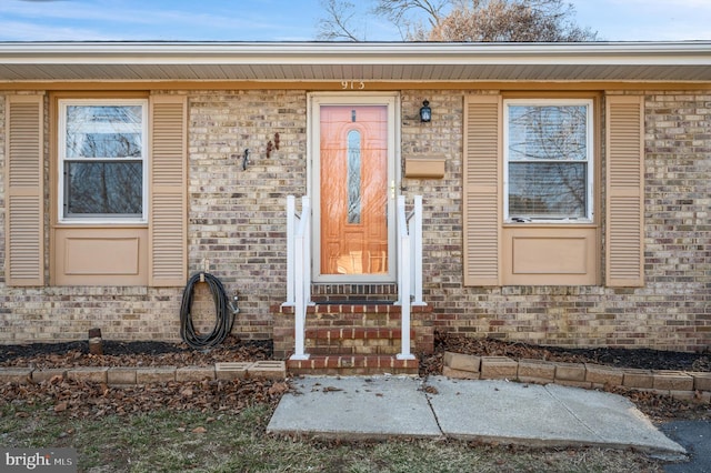 doorway to property featuring brick siding