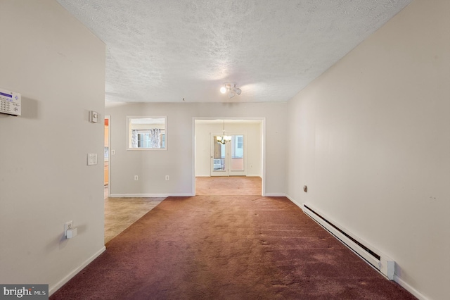 carpeted empty room featuring baseboards, baseboard heating, and a textured ceiling