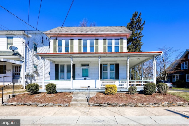 view of front facade with covered porch and a shingled roof