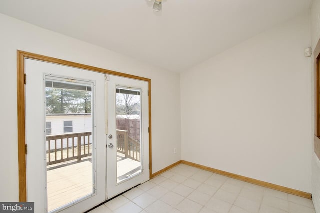 entryway with lofted ceiling, baseboards, and french doors