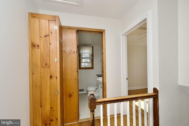 corridor featuring visible vents and baseboards