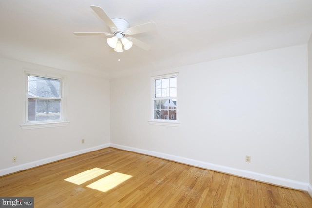 spare room with ceiling fan, baseboards, and wood finished floors