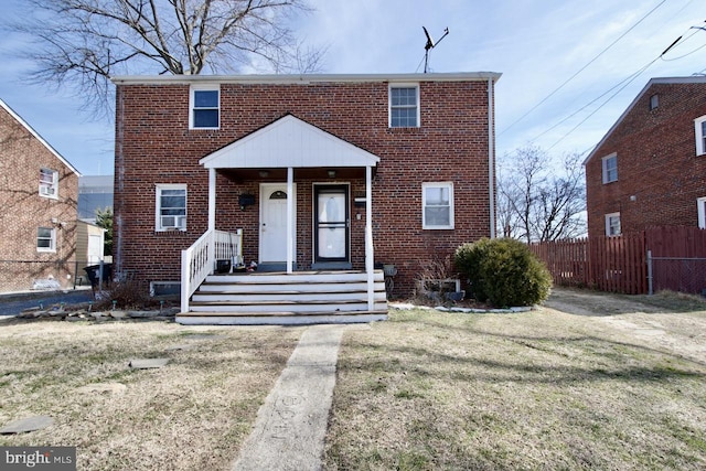 view of front of house with brick siding, a porch, and fence