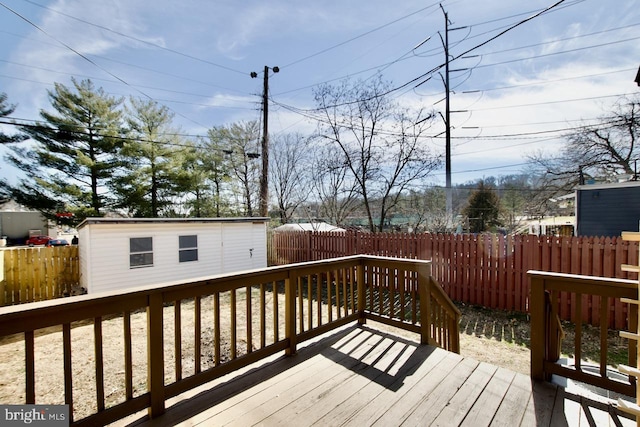 deck featuring an outdoor structure and a fenced backyard