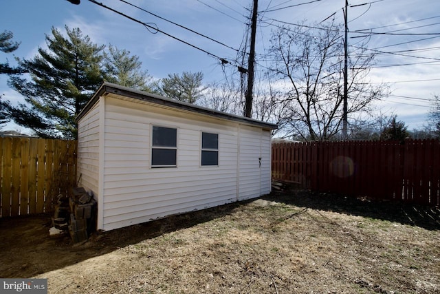 view of outbuilding with a fenced backyard and an outbuilding