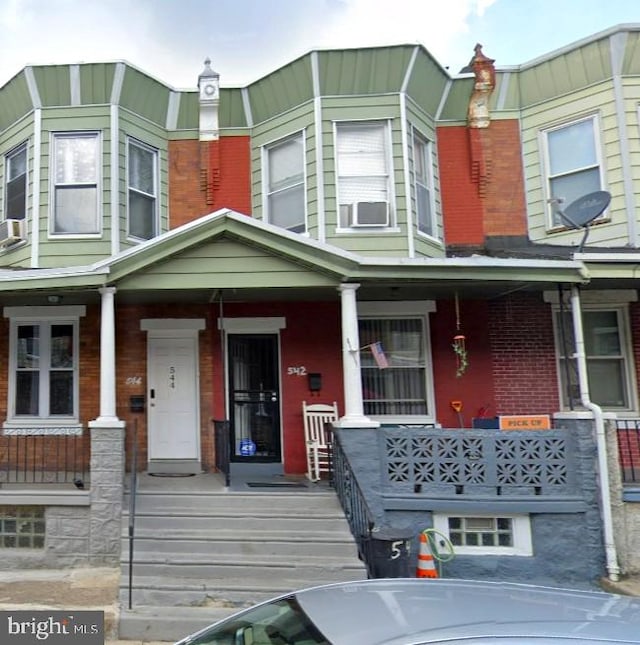 multi unit property featuring covered porch and brick siding