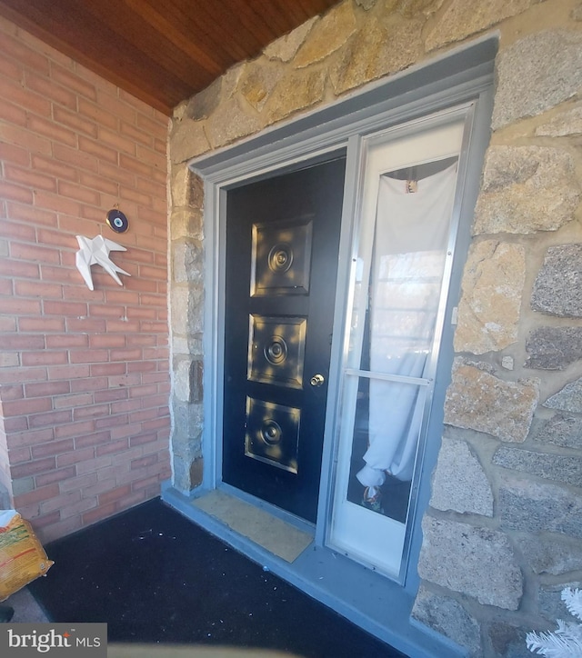 entrance to property featuring brick siding