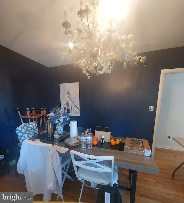 dining area with wood finished floors, baseboards, and a chandelier