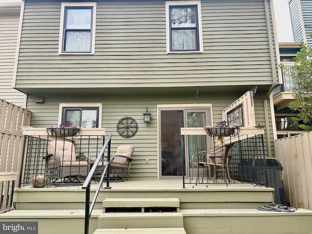 rear view of house featuring a deck, stairway, cooling unit, and fence