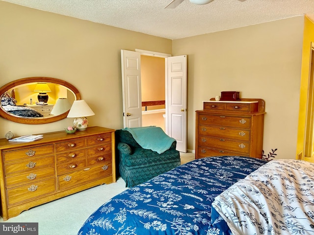 bedroom featuring a textured ceiling and light colored carpet