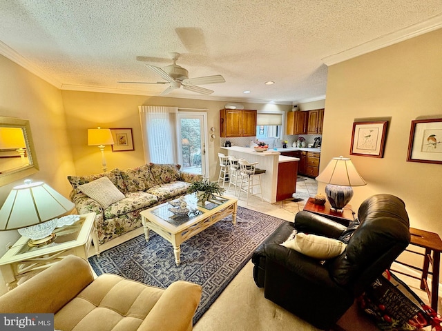 living area with a textured ceiling, light tile patterned flooring, a ceiling fan, and crown molding