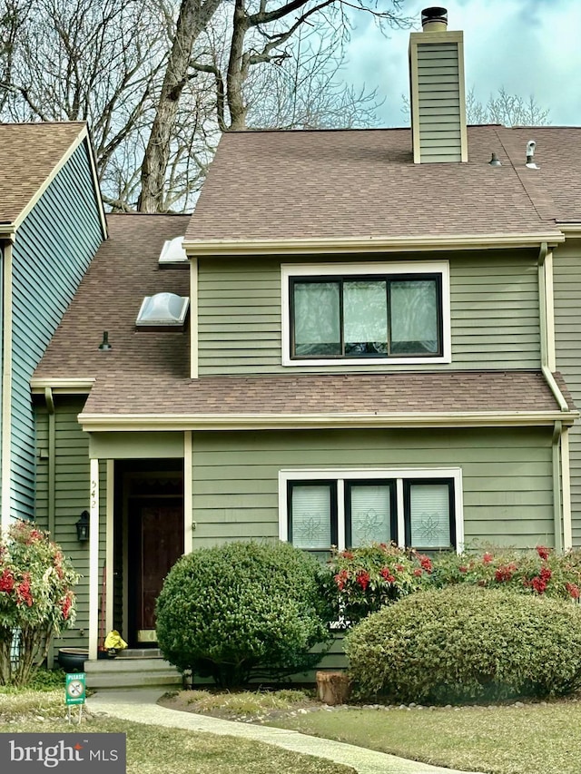 view of front of house featuring a shingled roof and a chimney