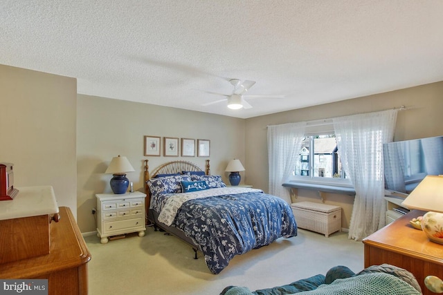 bedroom featuring a textured ceiling, ceiling fan, carpet, and baseboards