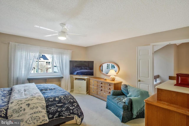 carpeted bedroom featuring ceiling fan and a textured ceiling