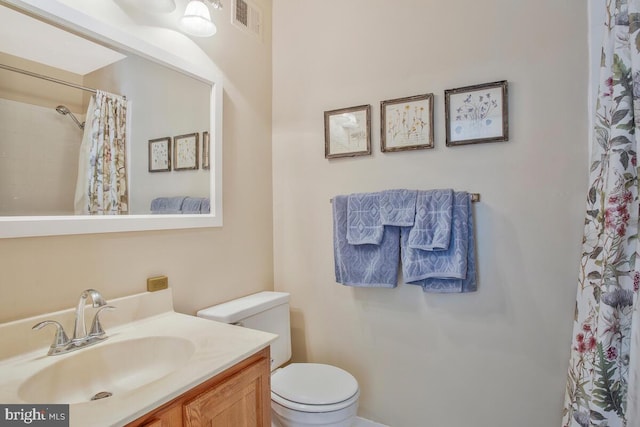 full bathroom featuring visible vents, a shower with shower curtain, vanity, and toilet