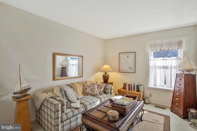 living room with visible vents, light carpet, and a textured ceiling