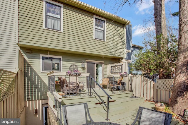 back of house featuring fence and a deck