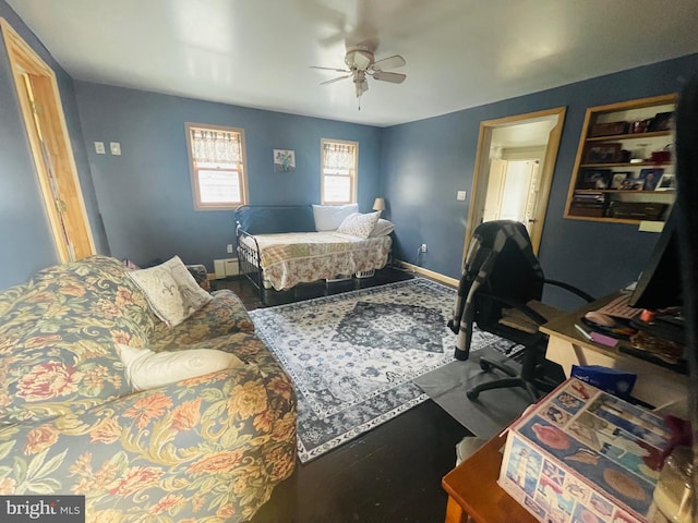 bedroom with a ceiling fan, baseboards, and wood finished floors