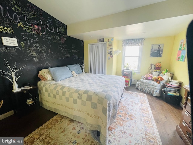 bedroom featuring a baseboard heating unit and wood finished floors