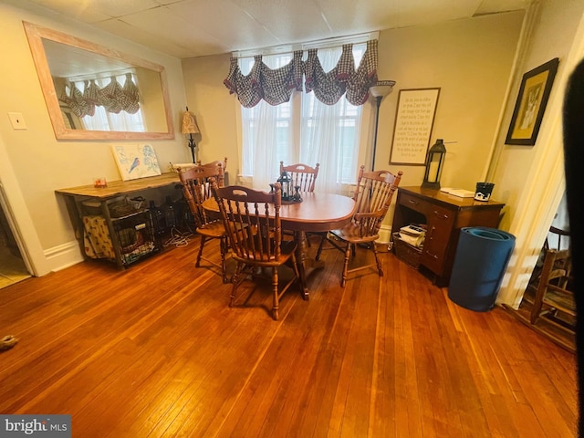 dining space with baseboards and hardwood / wood-style flooring